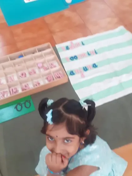 This child's shy smile shows her pride in her work. The Movable Alphabet empowers children to write their own stories and ideas.