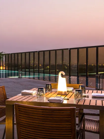 A serene poolside dining setup at dusk. This image highlights the tranquil and upscale ambiance available for a sophisticated evening of drinks and conversation.