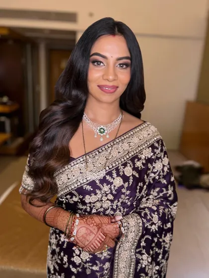 A smiling portrait that radiates elegance and beauty. The makeup is designed to enhance her features and complete the classic look.