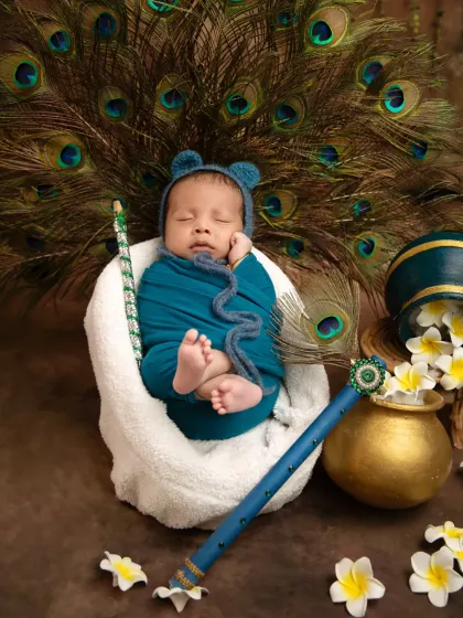 This overhead shot shows the full arrangement of the props, with the baby peacefully sleeping at the center of the beautiful Janmashtami theme.
