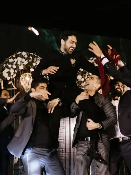 The groom being lifted by his friends in celebration. These are the spontaneous, joyous moments that make a sangeet night so memorable.