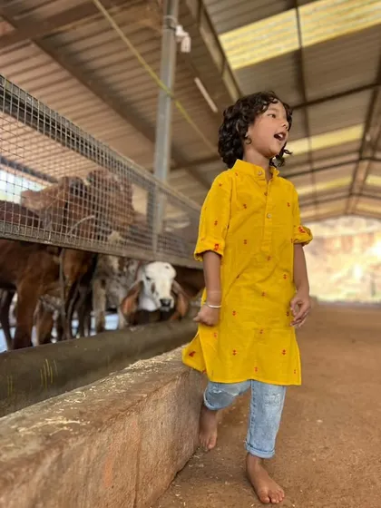 Being kind to all beings is a lesson I cherish. This little boy is wearing our yellow handloom cotton kurta while visiting a goshala, looking comfortable and stylish.