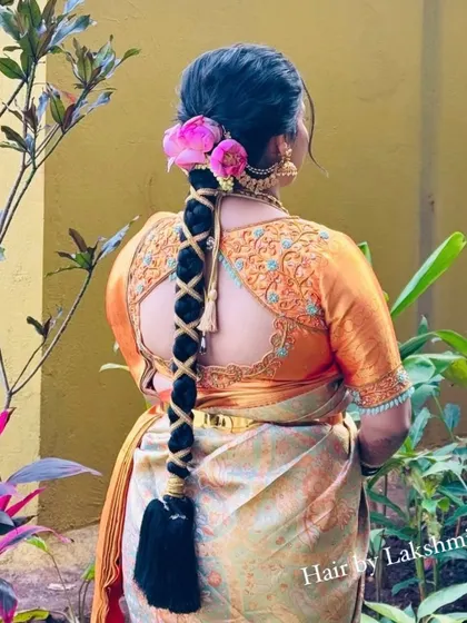 A beautiful criss-cross patterned braid adorned with fresh pink flowers. This intricate design adds a unique touch to the classic long braid.