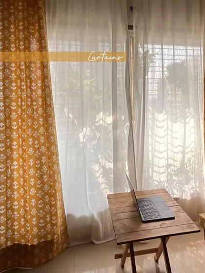 The matching curtains create a beautiful backdrop, filtering the sunlight and casting soft shadows, enhancing the warm and inviting feel of the space.