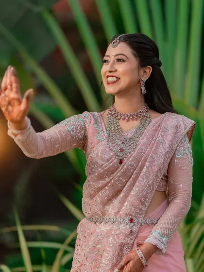 A candid shot of the bride waving happily during her reception, her joy lighting up the frame.