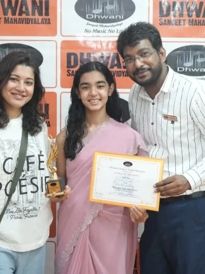 A student and her mother with her teacher, celebrating her success.