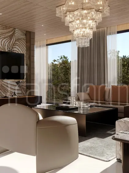A closer look at the living area, featuring a tiered crystal chandelier and large windows that connect the interior with the lush greenery outside. The design is opulent yet feels light and airy.