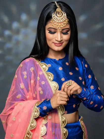 This shot captures a candid moment, showing how the makeup looks natural even in a more relaxed pose. The focus is on creating a look that empowers the wearer.
