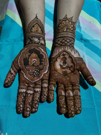 This Karwa Chauth design features portraits of a woman and a peacock, each enclosed in an ornate, scalloped frame. The surrounding patterns are filled with fine details for a traditional look.