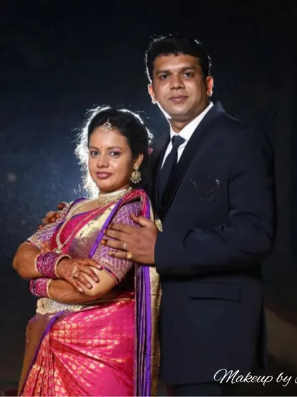 A stylish couple's portrait from their reception. The lighting highlights the bride's glowing skin and the beautiful details of her saree and makeup.