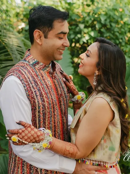 The couple sharing a loving gaze amidst a lush green background.