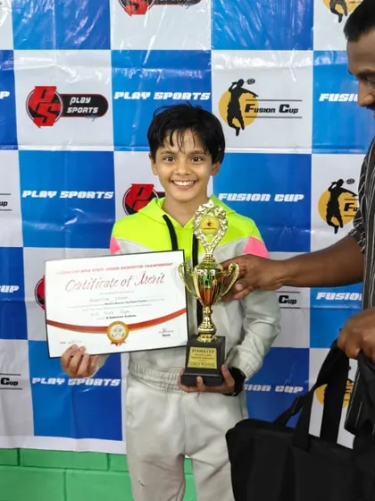 Head Coach Sathiya Moorthy presenting the trophy to U-13 champion Anwesha Singh. This image highlights the close bond and mentorship between our coaches and young athletes.