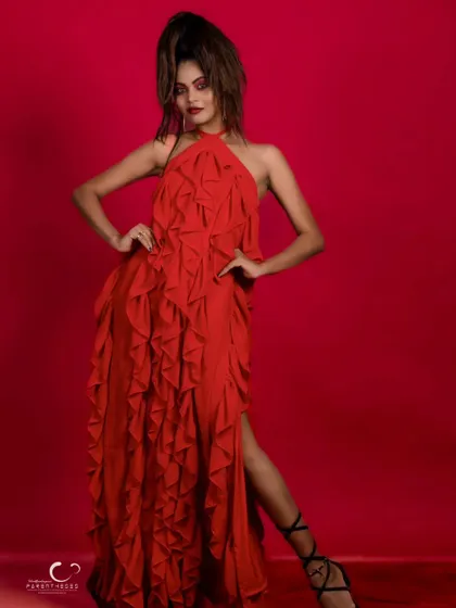 A full-length shot that captures the grandeur and drama of the red ruffled gown.