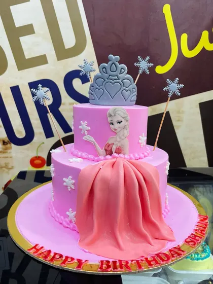 A pretty in pink 2.5kg Frozen theme cake with an edible Elsa image, fondant dress, and a tiara topper.