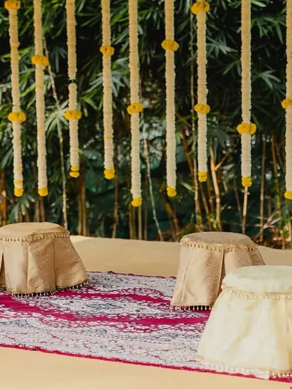 The seating arrangement for a traditional, eco-friendly ceremony, featuring low stools on a decorative rug.