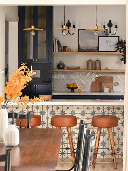 This view from the dining area shows how the breakfast bar creates a social, open connection to the kitchen. The warm leather stools and pendant lights make it an inviting spot, while the open shelves inside can be dressed up as a bar for entertaining.