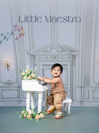 A little maestro in the making. This sitter session features a baby confidently playing at a miniature piano, showing off his curious and playful nature.
