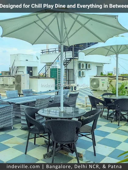 A closer look at the outdoor dining and seating arrangement on a multi-zone terrace. I sourced weatherproof rattan tables and chairs, complete with large umbrellas, to create a comfortable and practical area for enjoying meals outdoors.