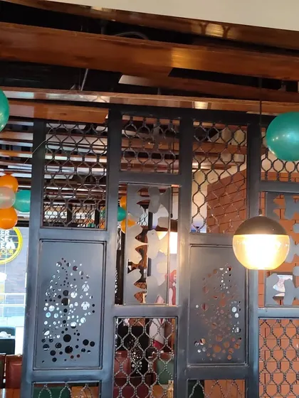 Interior decoration for a cafe using tricolor balloon bunches. The balloons are placed throughout the space to create a cohesive theme for an Independence Day celebration.