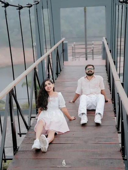 A relaxed moment, sitting together on the wooden planks of the bridge, enjoying the view.