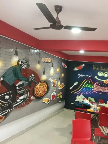 Another wall in the same cafe, featuring a large, graphic-style mural of a biker and pizza.