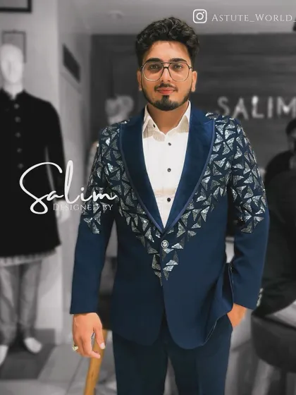 A client wearing a navy blue blazer with a velvet lapel and geometric silver embellishments. The triangular patterns give the jacket a modern, architectural feel.