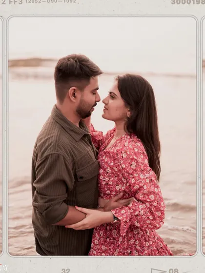 A romantic portrait of a couple by the sea, with a vintage film frame effect.