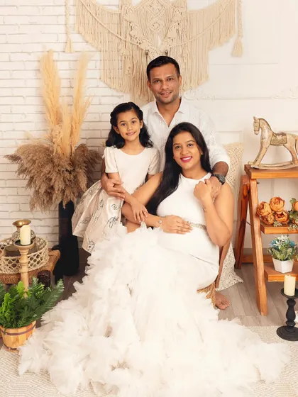 A classic family maternity portrait in my boho studio. The coordinating white outfits and the warm, rustic decor create a timeless and beautiful family keepsake.
