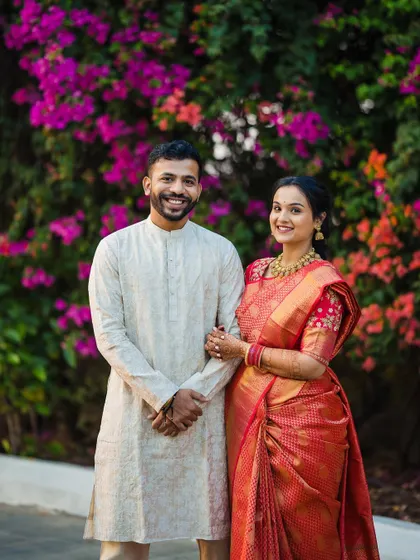 A classic, smiling portrait of the newly engaged couple against a beautiful floral background.