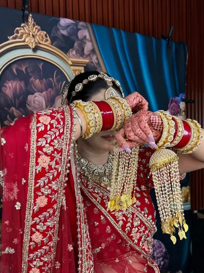 A series of portraits showcasing a bride in a traditional red lehenga. The focus is on the detailed craftsmanship of the outfit and the perfectly matched kundan jewellery.