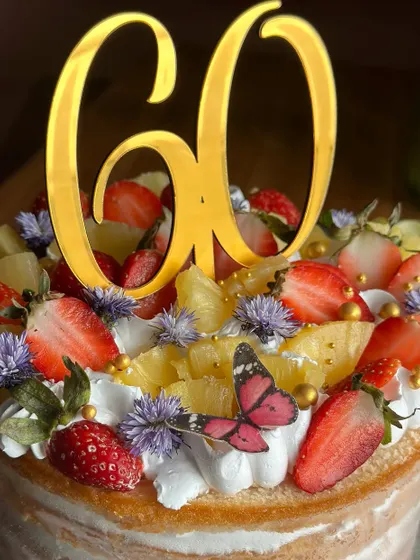 Berry sweet news! This fresh and fruity naked cake, topped with strawberries and pineapple, was the perfect way to celebrate a 60th birthday with natural elegance.