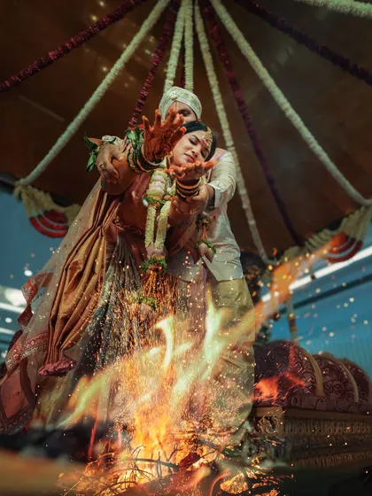 A powerful shot of the couple during a fire ritual, their hands extended over the sacred flames. I aim to capture the spiritual intensity and visual drama of these important wedding traditions.