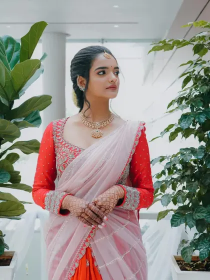 A full-length view of the modern lehenga-saree. The custom-designed red blouse is the perfect anchor for this unique and stylish outfit.