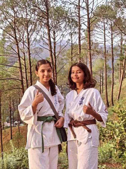 Two of my dedicated green and brown belt students, taking a moment during our mountain trek. Their thumbs-up says everything about the camp experience.