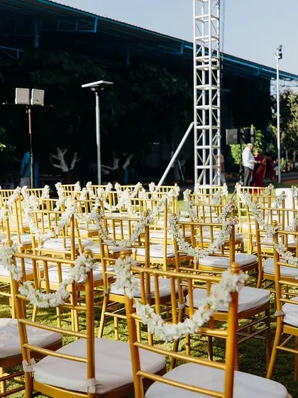 Guest seating with chairs adorned with simple white floral garlands.