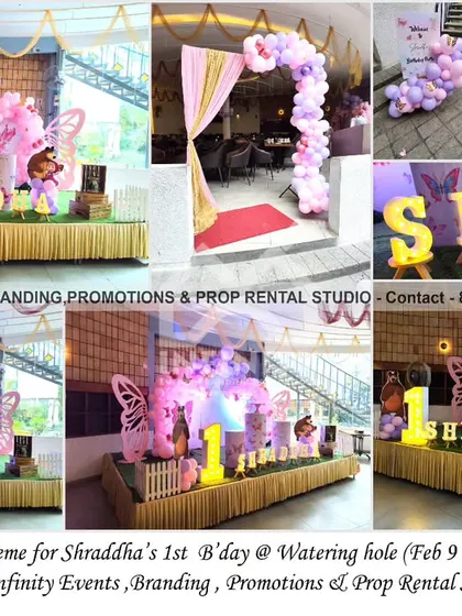 This pretty butterfly theme for a first birthday at Watering Hole features a semi-arch backdrop with a pink and purple balloon garland. A large "ONE" table and marquee letters complete the enchanting setup.