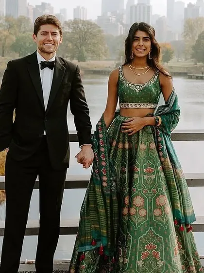A repeat of a beautiful fusion look. I can design a similar printed green lehenga for her, which pairs beautifully with his classic tuxedo for a modern reception.