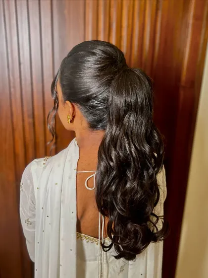 The back view of the high curly ponytail, showing off its volume and bounce.