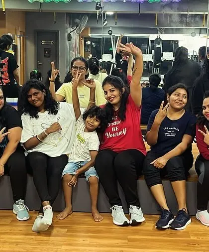 Our members, including a young fitness enthusiast, taking a moment to celebrate a completed class. We welcome people of all ages and fitness levels to our community.