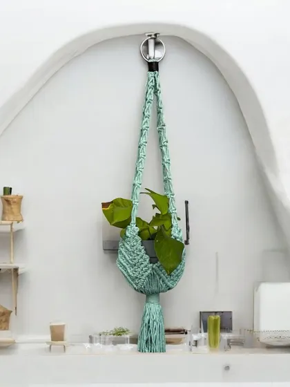 A professionally styled shot of my mint green macrame plant hanger. It looks so fresh and modern in this clean, white space, adding a pop of color and life.