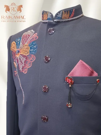 A detailed shot of the pocket square and brooch complementing the colorful floral embroidery.