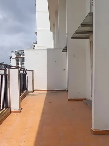 **BEFORE:** A standard, unused penthouse balcony with plain terracotta tiles and an exposed railing, offering little function or appeal.