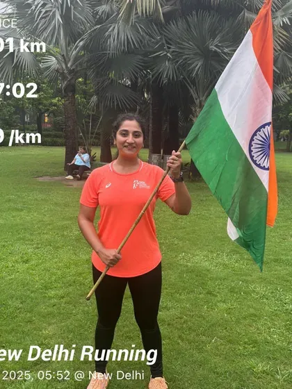 A female member after a 25km Independence Day run, holding the flag. Her dedication to both running and her country is inspiring.