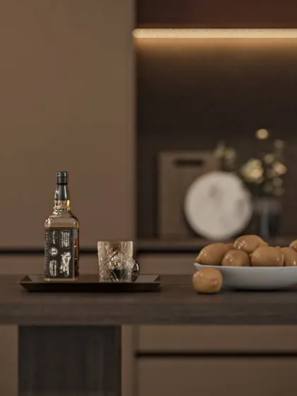 The kitchen island doubles as a casual dining or serving space. The dark wood finish of the breakfast counter extension complements the overall color scheme.