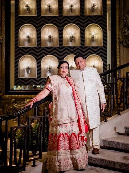 A classic portrait of the couple on the grand staircase during their 50th-anniversary celebration, looking regal and happy.