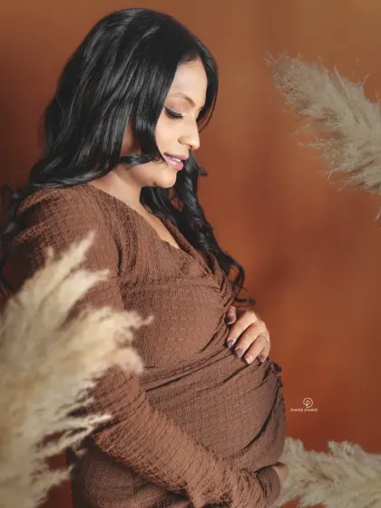 A quiet, beautiful moment captured during a boho-themed studio session. The soft lighting and natural textures complement the simple elegance of this maternity portrait.