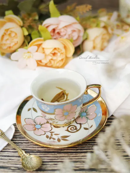 This frame is about the feeling of pausing to savor something delicate. A single jasmine pearl unfurls in a vintage-style teacup, surrounded by soft florals, creating a poetic and beautiful moment.