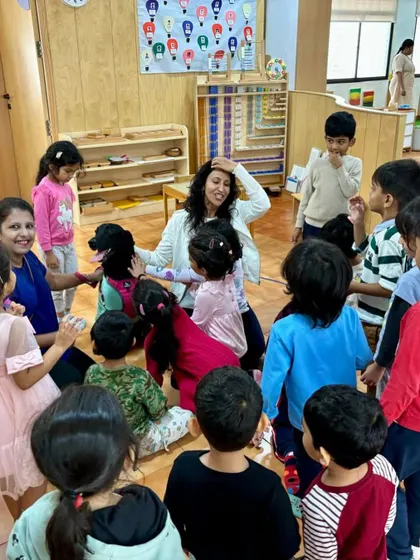 A teacher sits on the floor with the children during a pet visit, creating a circle of warmth and curiosity. Our mentors guide children to interact gently and respectfully with animals.