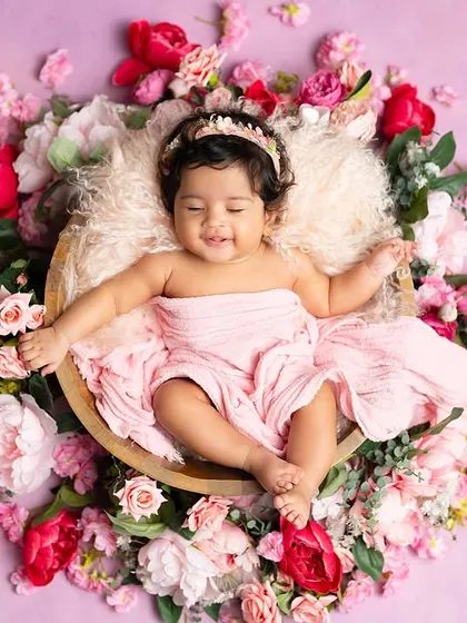 A sleepy, happy baby surrounded by a wreath of pink flowers. This is a beautiful and serene way to capture a three-month milestone.
