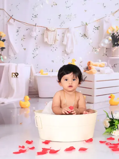 A happy baby plays in a mini tub, surrounded by toys and bubbles. The clean, bright setup with yellow and white accents creates a cheerful and timeless look.